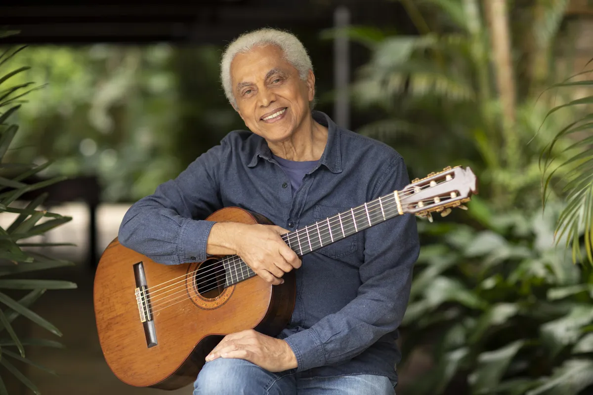 Paulinho da Viola em foto posada com um violão